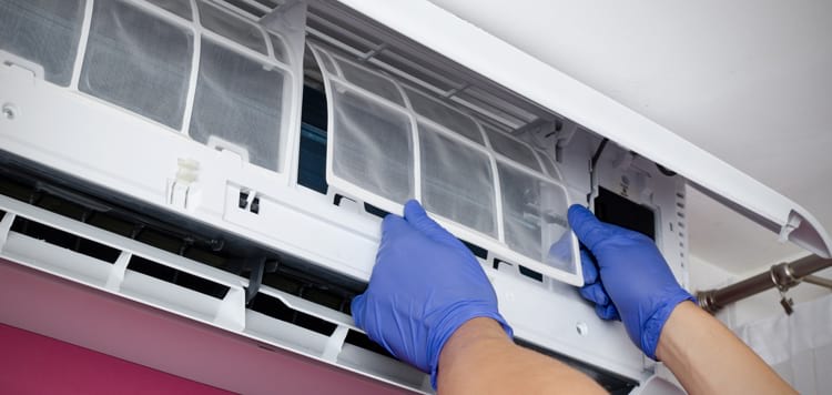 Air conditioner cleaning when man checks the filter