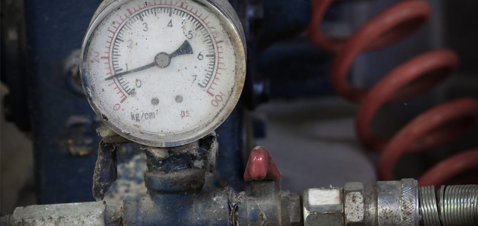 A pressure gauge on an old boiler that shows signs of needing replacement.