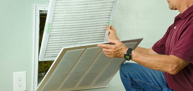 Changing the air filter for increased indoor air quality.
